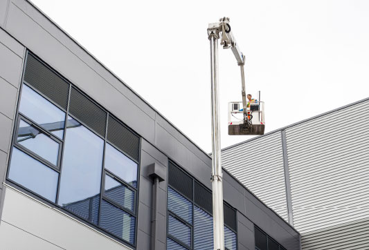 Cherry picker being used to clean a building